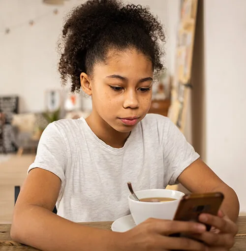niña usando el teléfono móvil